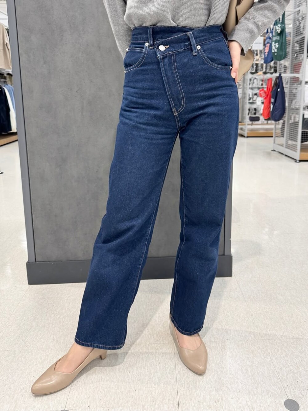 ブルー系のデニムパンツ、グレー系のニット/セーター、ベージュ系のパンプスを着用したレディースの冬コーディネートの2枚目の写真