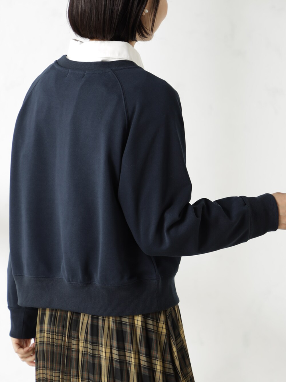 ブラウン系のスカート、ブラック系のブーツ、ブルー系のスウェットを着用したレディースの冬コーディネートの3枚目の写真