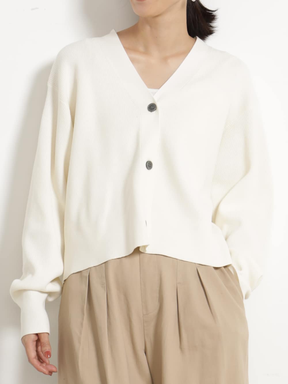 ベージュ系のチノパンツ、ホワイト系のカーディガン/ボレロを着用したレディースの秋コーディネートの2枚目の写真