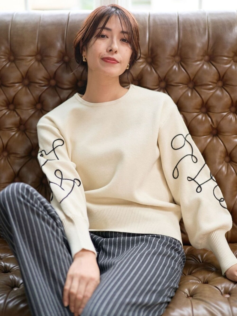 ベージュ系のニット/セーターを着用したレディースの秋コーディネートの2枚目の写真