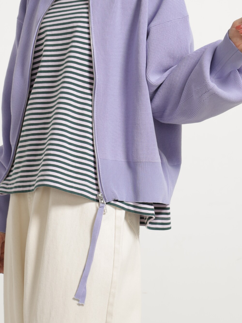 パープル系のブルゾン、ホワイト系のデニムパンツを着用したレディースの秋コーディネートの3枚目の写真