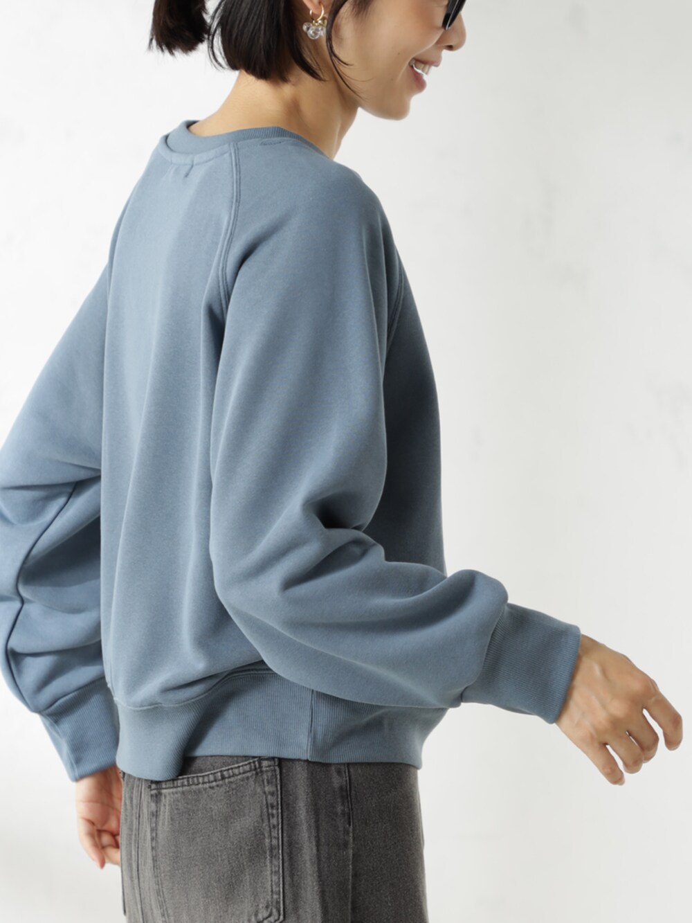 グレー系のスカート、ブルー系のスウェットを着用したレディースの冬コーディネートの3枚目の写真