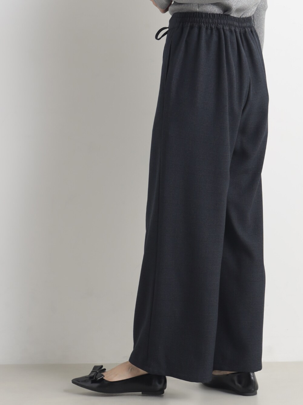 グレー系のニット/セーター、ブルー系のその他パンツを着用したレディースの冬コーディネートの4枚目の写真