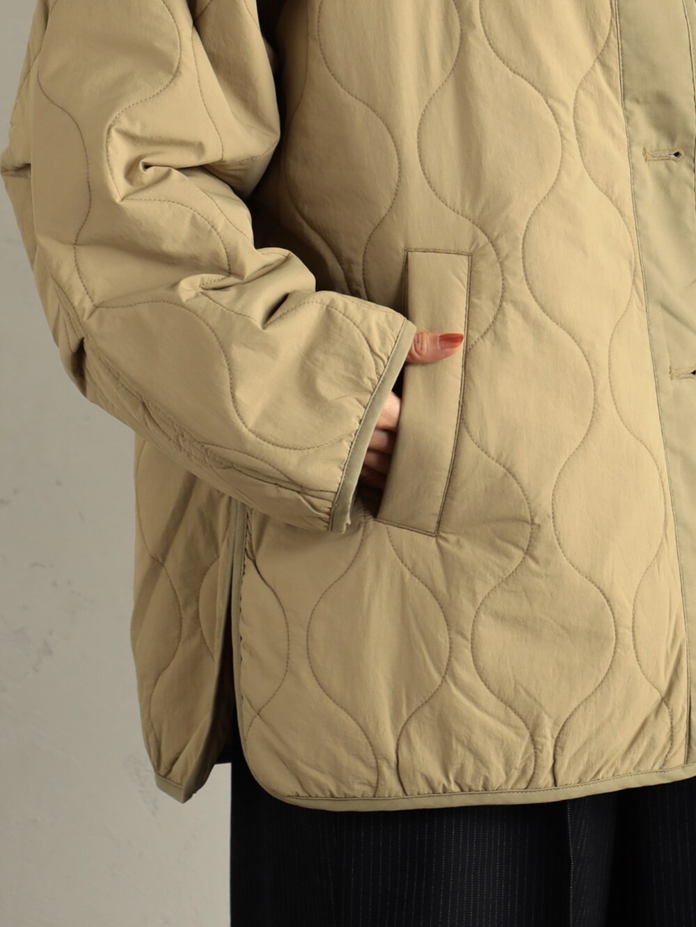 ベージュ系のブーツ、ベージュ系のブルゾン、ホワイト系のTシャツ/カットソーを着用したレディースの冬コーディネートの2枚目の写真