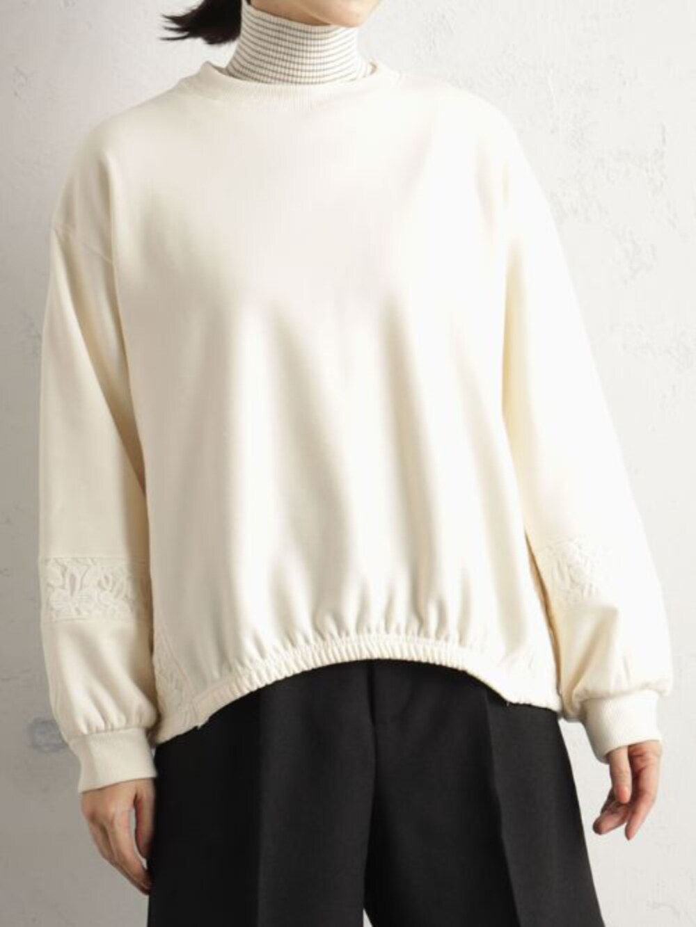 ブラック系のショルダーバッグ、ブラック系のその他パンツ、ベージュ系のTシャツ/カットソーを着用したレディースの冬コーディネートの2枚目の写真