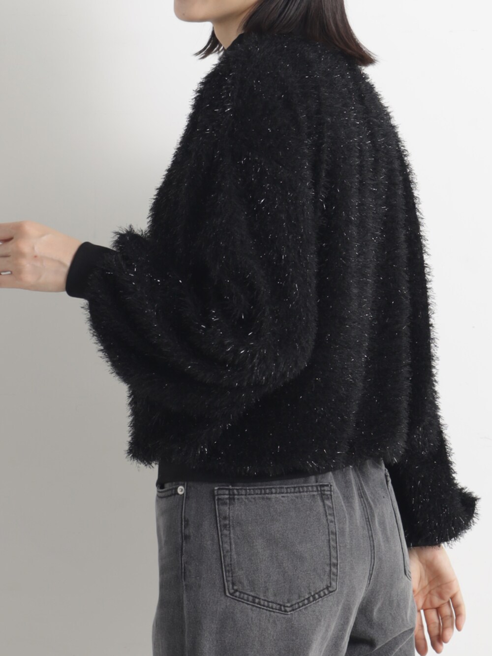 ブラック系のパンプス、グレー系のデニムパンツ、ブラック系のその他トップスを着用したレディースの冬コーディネートの3枚目の写真