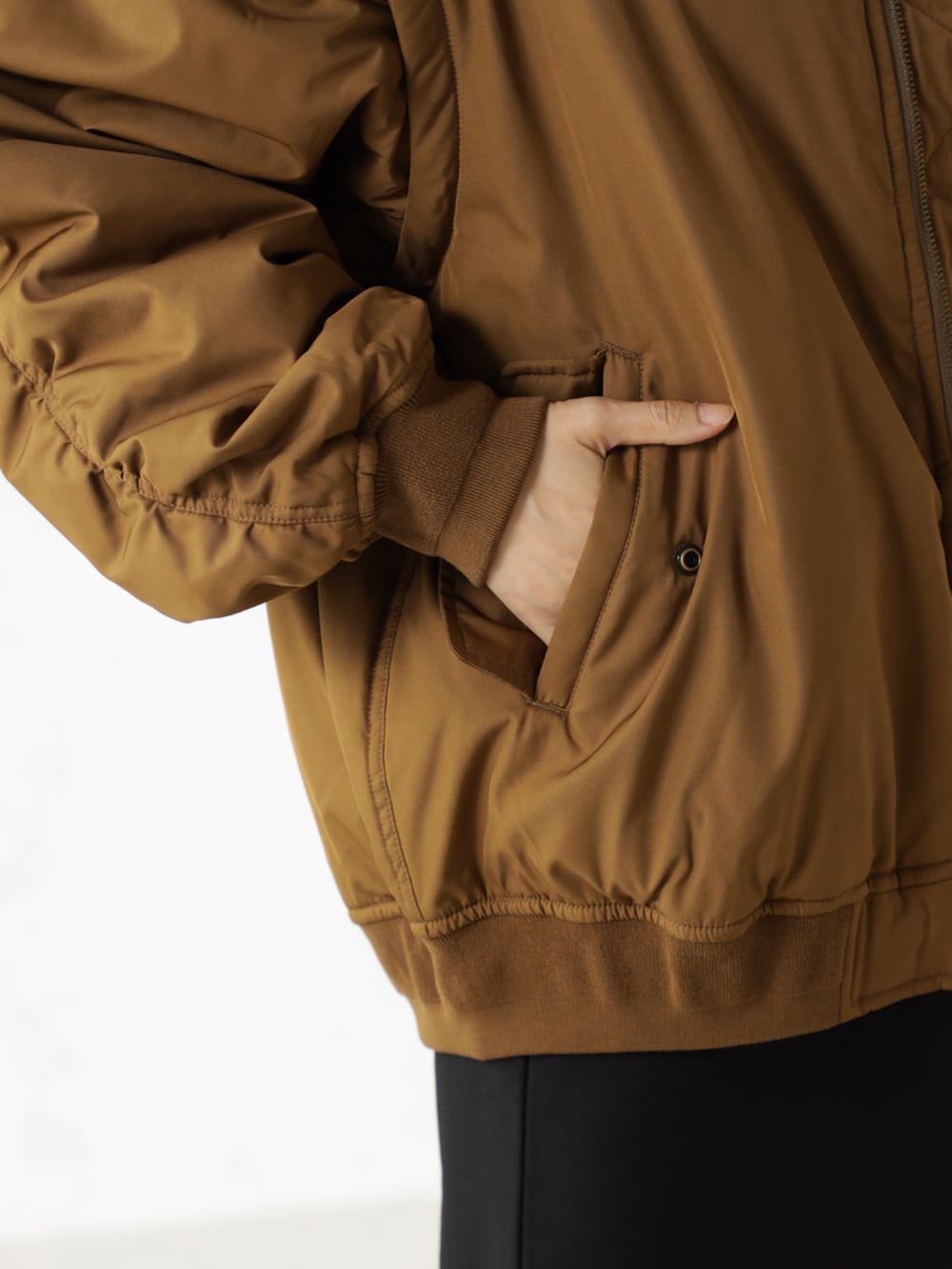 ブラック系のブーツ、ブラウン系のMA-1、ブラック系のスカートを着用したレディースの秋コーディネートの3枚目の写真