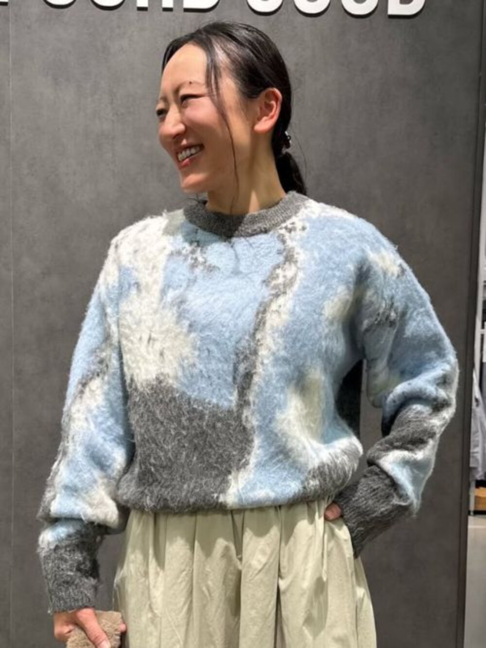 ベージュ系のブーツ、ブルー系のニット/セーター、ベージュ系のスカートを着用したレディースの冬コーディネートの2枚目の写真