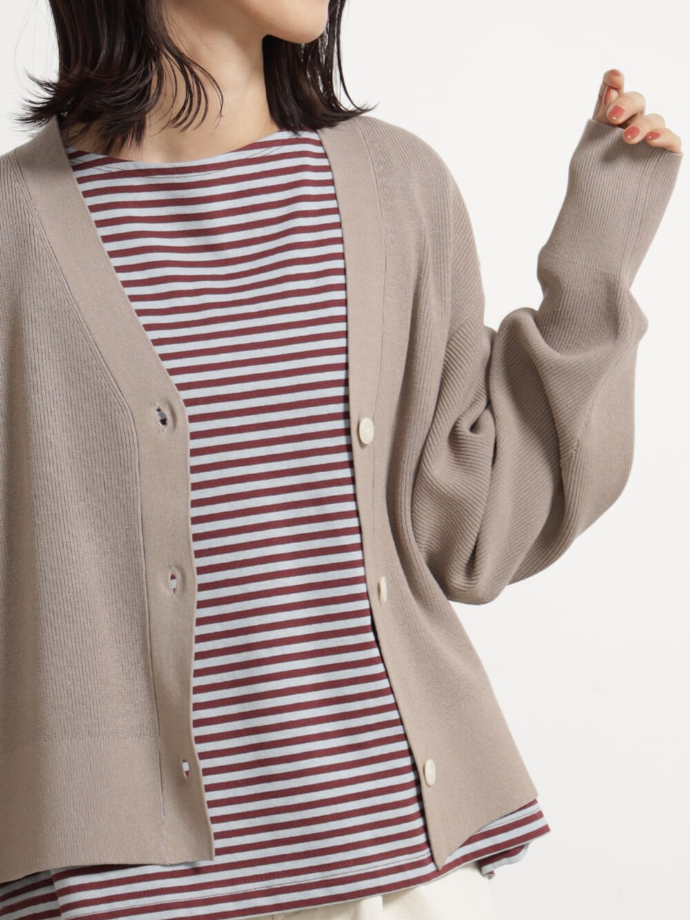 レッド系のTシャツ/カットソー、ホワイト系のデニムパンツ、ベージュ系のカーディガン/ボレロを着用したレディースの秋コーディネートの3枚目の写真