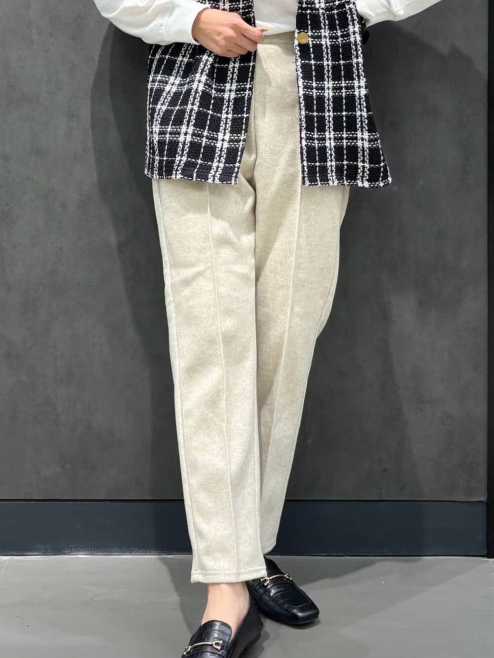 ホワイト系のTシャツ/カットソー、ベージュ系のその他パンツ、ブラック系のベストを着用したレディースの冬コーディネートの3枚目の写真