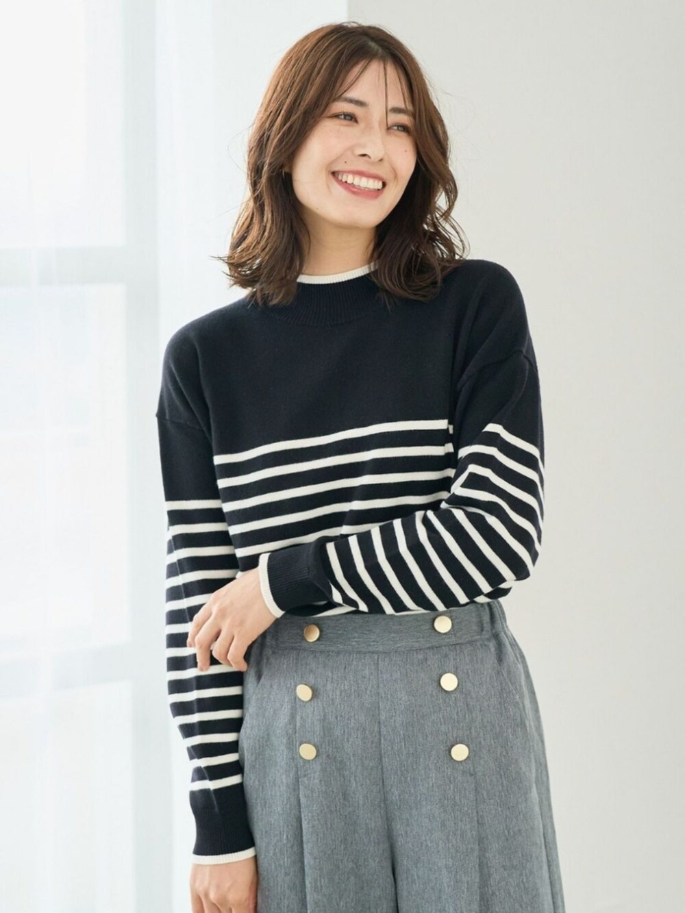 グレー系のニット/セーターを着用したレディースの秋コーディネートの2枚目の写真