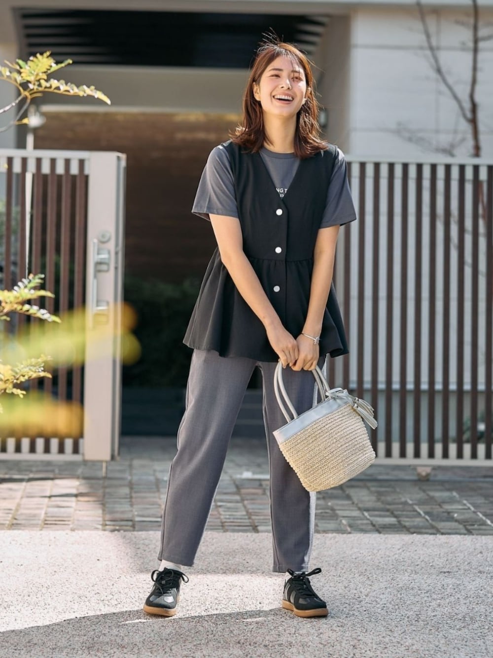 ブラック系のベストを着用したレディースの春コーディネートの2枚目の写真