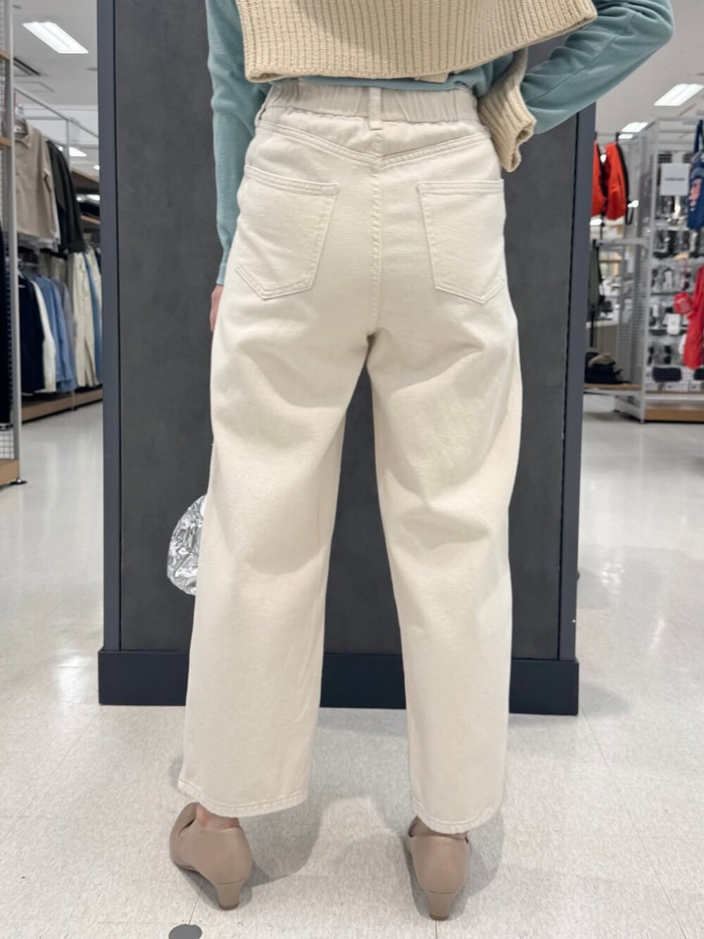 ベージュ系のニット/セーター、ベージュ系のパンプス、ホワイト系のデニムパンツを着用したレディースの冬コーディネートの3枚目の写真