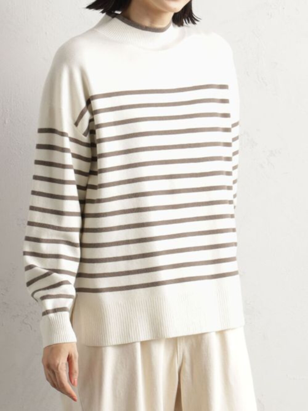 ブラウン系のブーツ、グレー系のニット/セーター、ホワイト系のその他パンツを着用したレディースの冬コーディネートの2枚目の写真