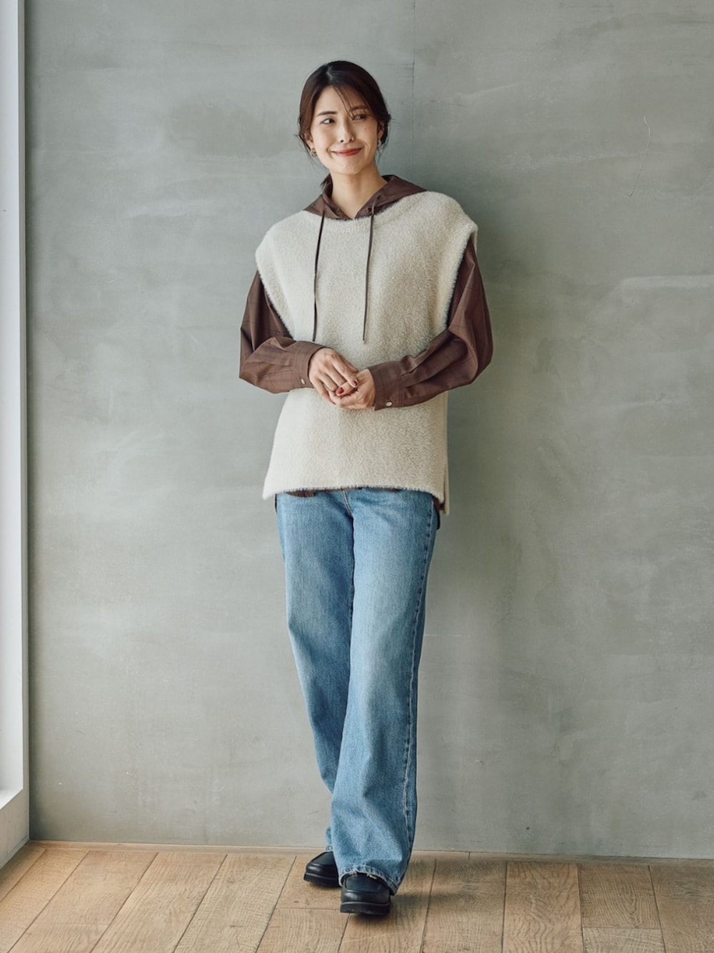 ベージュ系のベストを着用したレディースの秋コーディネートの2枚目の写真