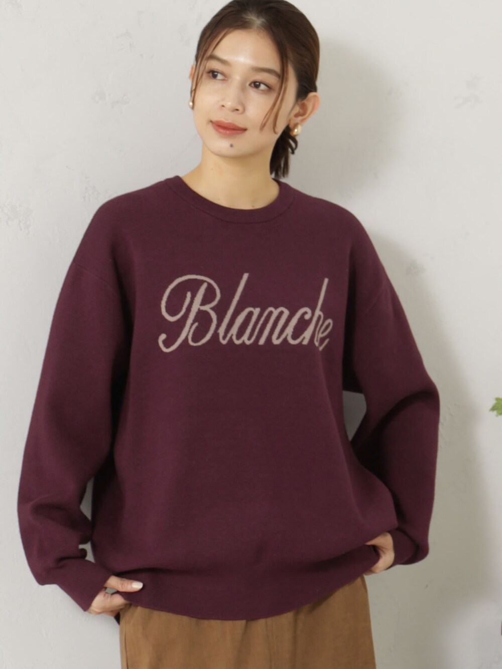 ベージュ系のブーツ、レッド系のニット/セーター、ベージュ系のスカートを着用したレディースの冬コーディネートの2枚目の写真