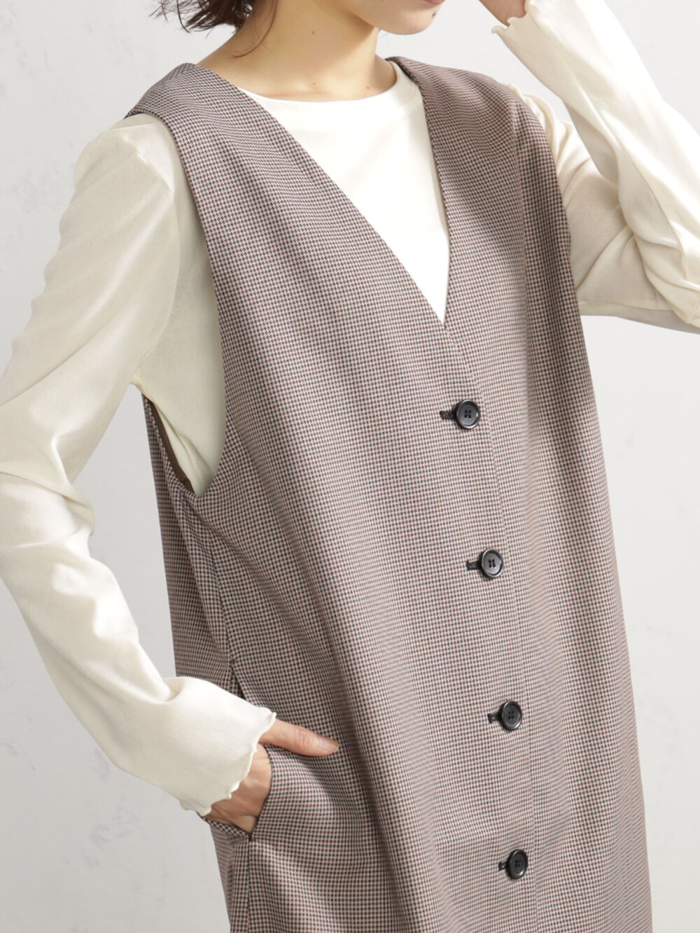 レッド系のワンピース、ブラウン系のブーツを着用したレディースの秋コーディネートの2枚目の写真