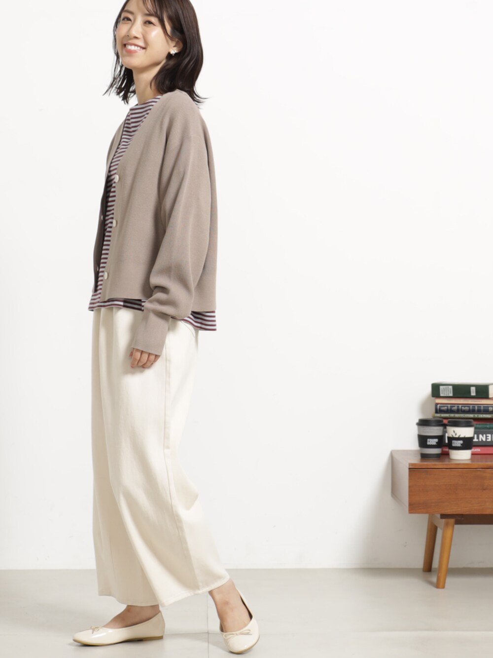 レッド系のTシャツ/カットソー、ホワイト系のデニムパンツ、ベージュ系のカーディガン/ボレロを着用したレディースの秋コーディネートの2枚目の写真