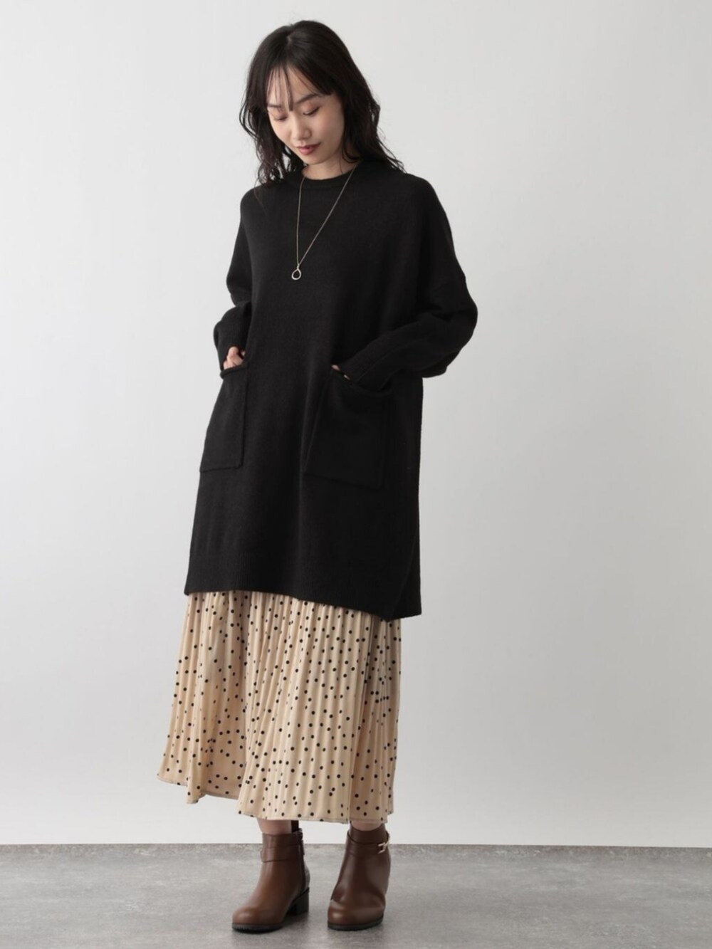 ブラック系のニット/セーターを着用したレディースの秋コーディネートの2枚目の写真