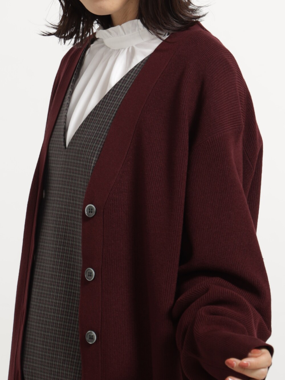 ブラック系のブーツ、ブラック系のボストンバッグ、レッド系のカーディガン/ボレロを着用したレディースの秋コーディネートの3枚目の写真