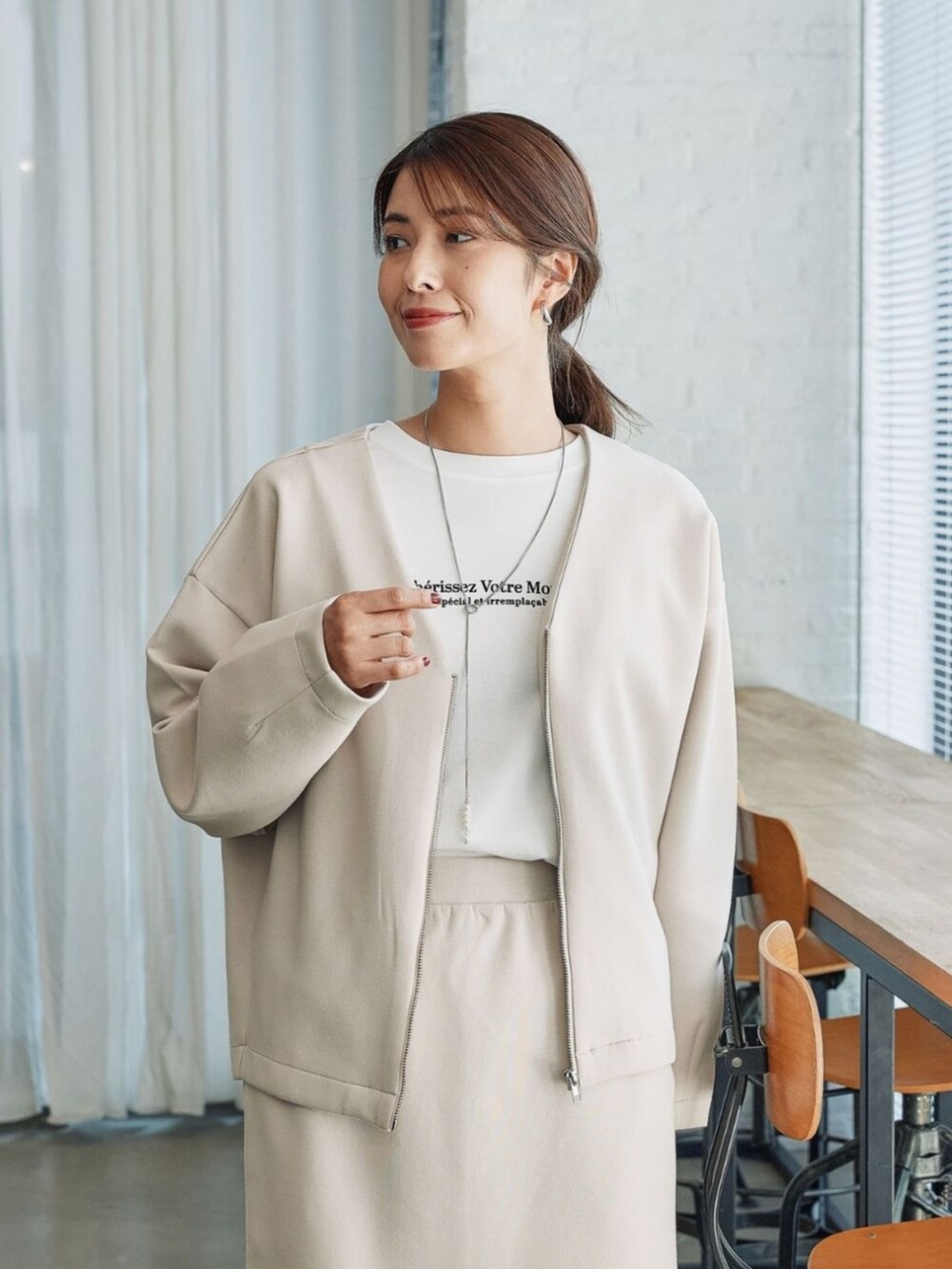 ベージュ系のブルゾンを着用したレディースの秋コーディネートの2枚目の写真