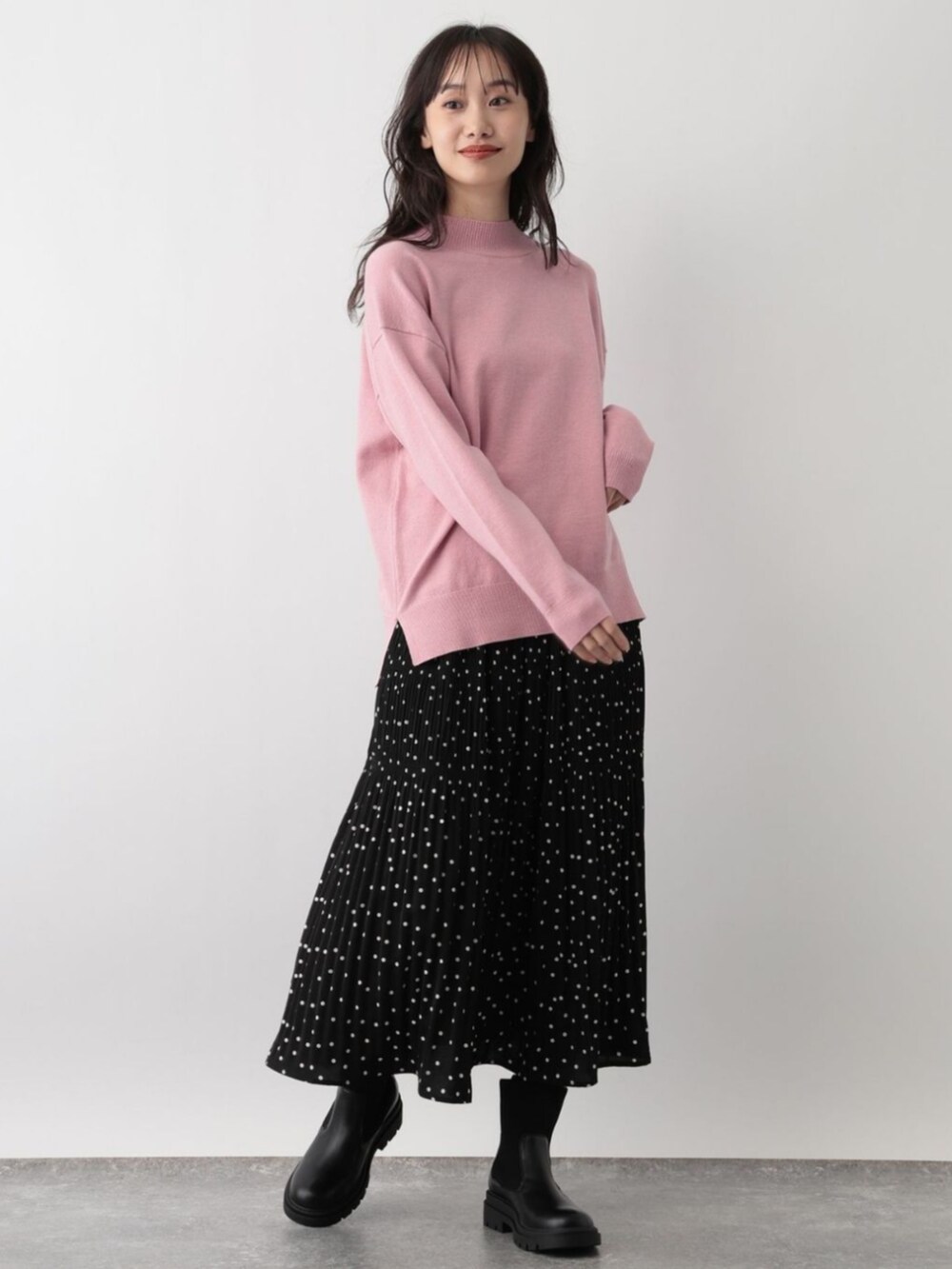 ピンク系のニット/セーターを着用したレディースの秋コーディネートの2枚目の写真