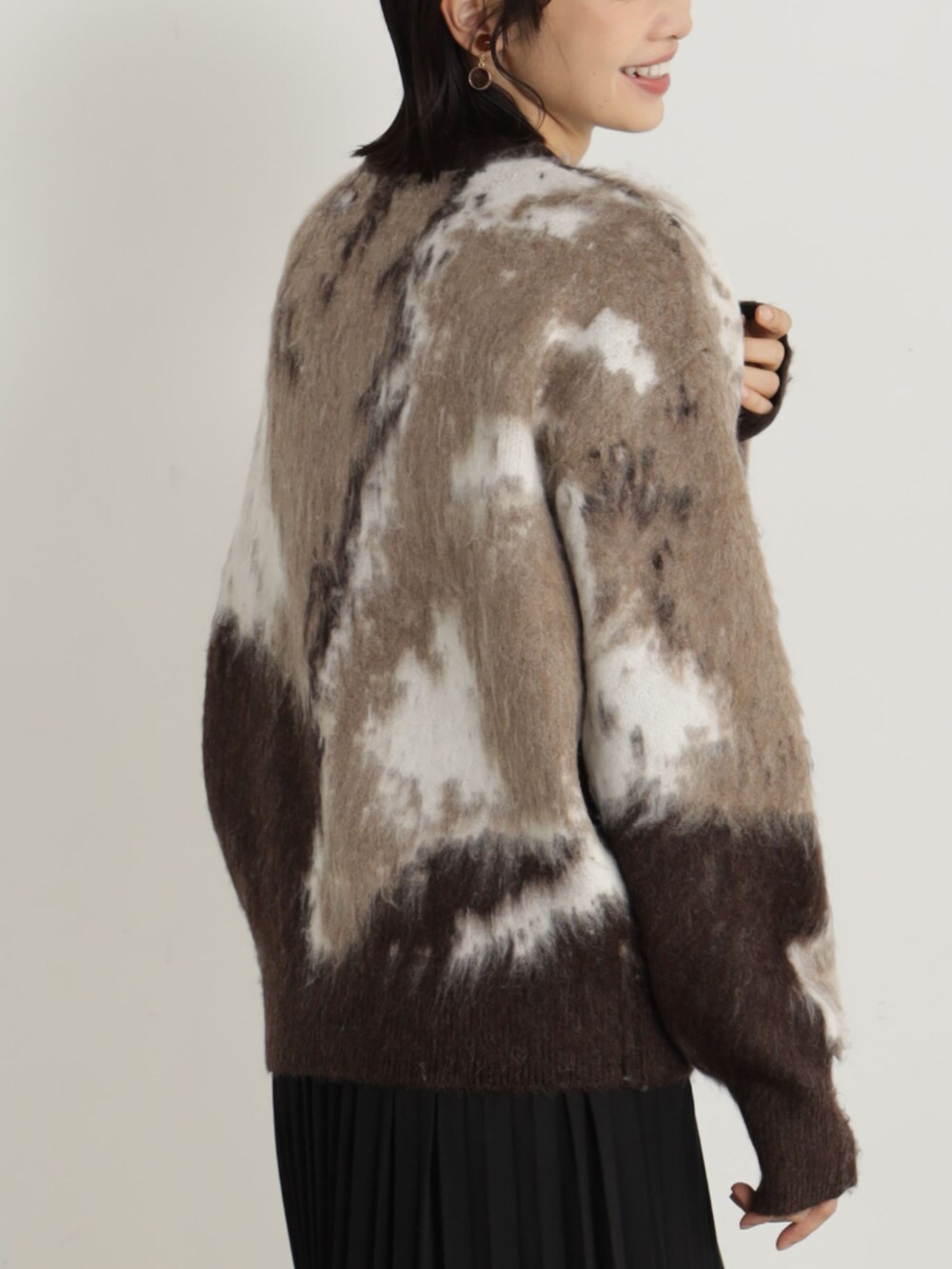 ブラック系のブーツ、ブラック系のショルダーバッグ、ブラック系のスカートを着用したレディースの冬コーディネートの3枚目の写真