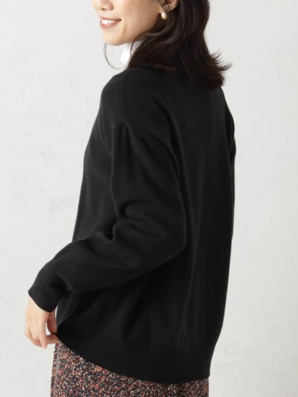 ブラック系のボストンバッグ、レッド系のスカート、ブラック系のカーディガン/ボレロを着用したレディースの冬コーディネートの3枚目の写真