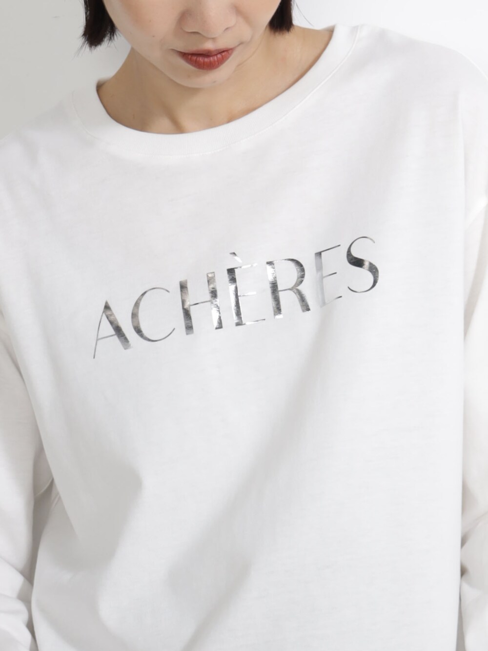 ベージュ系のTシャツ/カットソー、パープル系のキャップを着用したレディースの秋コーディネートの3枚目の写真