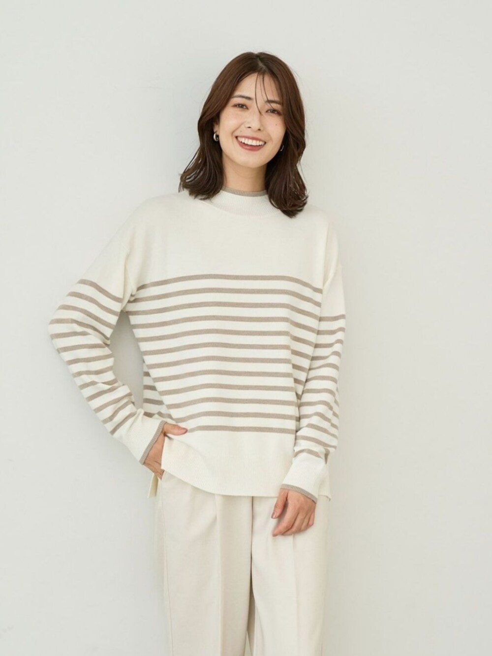 ブラウン系のニット/セーターを着用したレディースの冬コーディネートの2枚目の写真