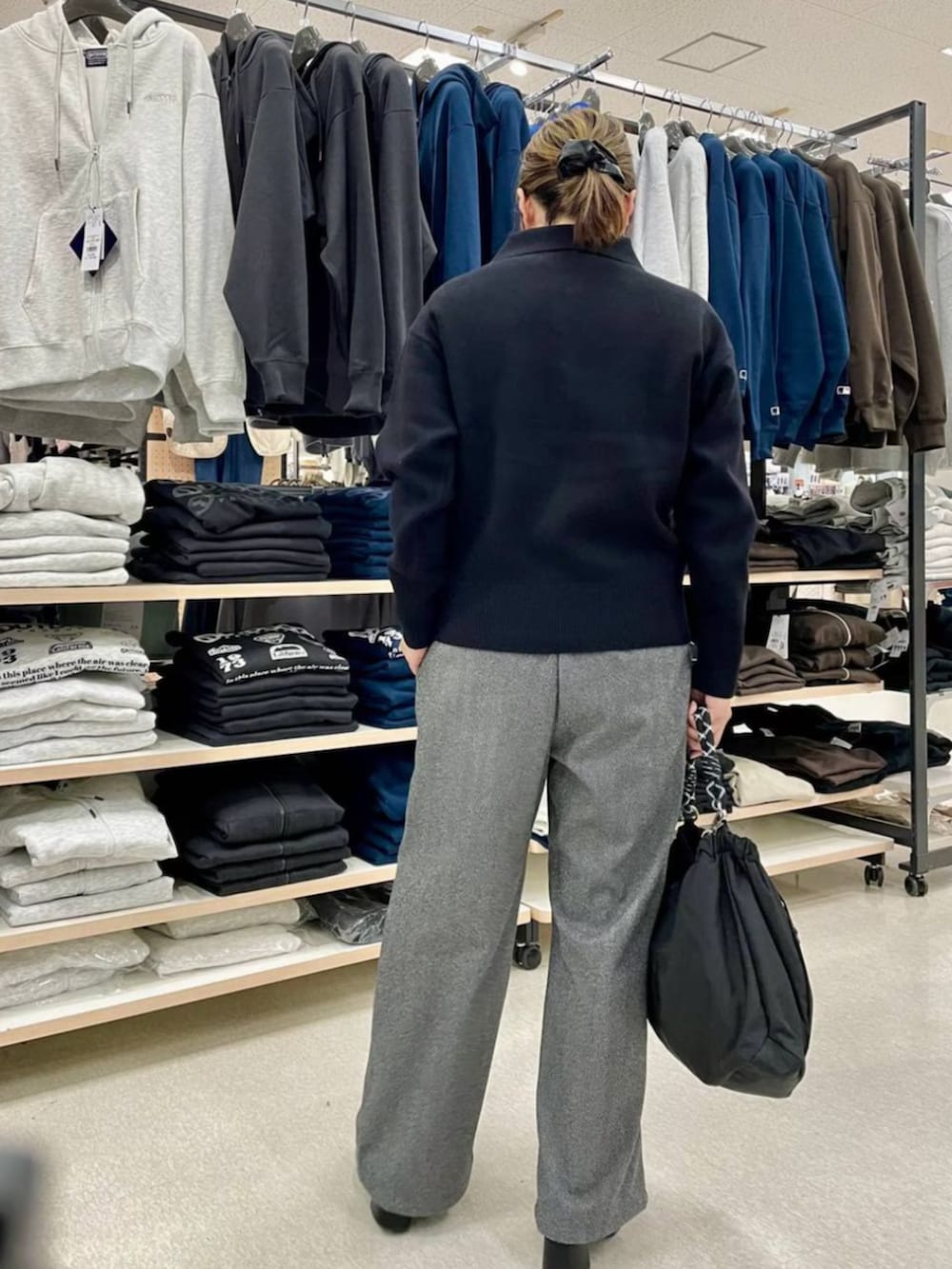 ブラック系のトップスを着用したレディースの春コーディネートの3枚目の写真