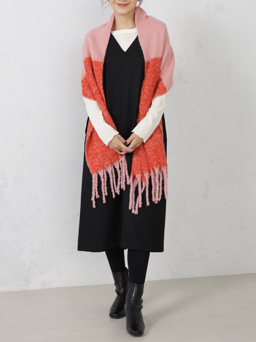 ブラック系のワンピース、ピンク系のマフラーを着用したレディースの秋コーディネートの3枚目の写真