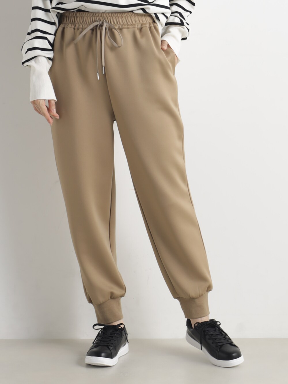 グレー系のニット/セーター、ブラウン系のその他パンツを着用したレディースの春コーディネートの2枚目の写真