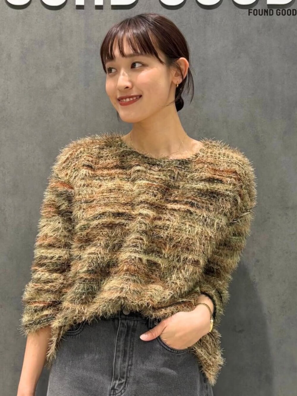 グレー系のスカート、グリーン系のその他トップスを着用したレディースの冬コーディネートの2枚目の写真