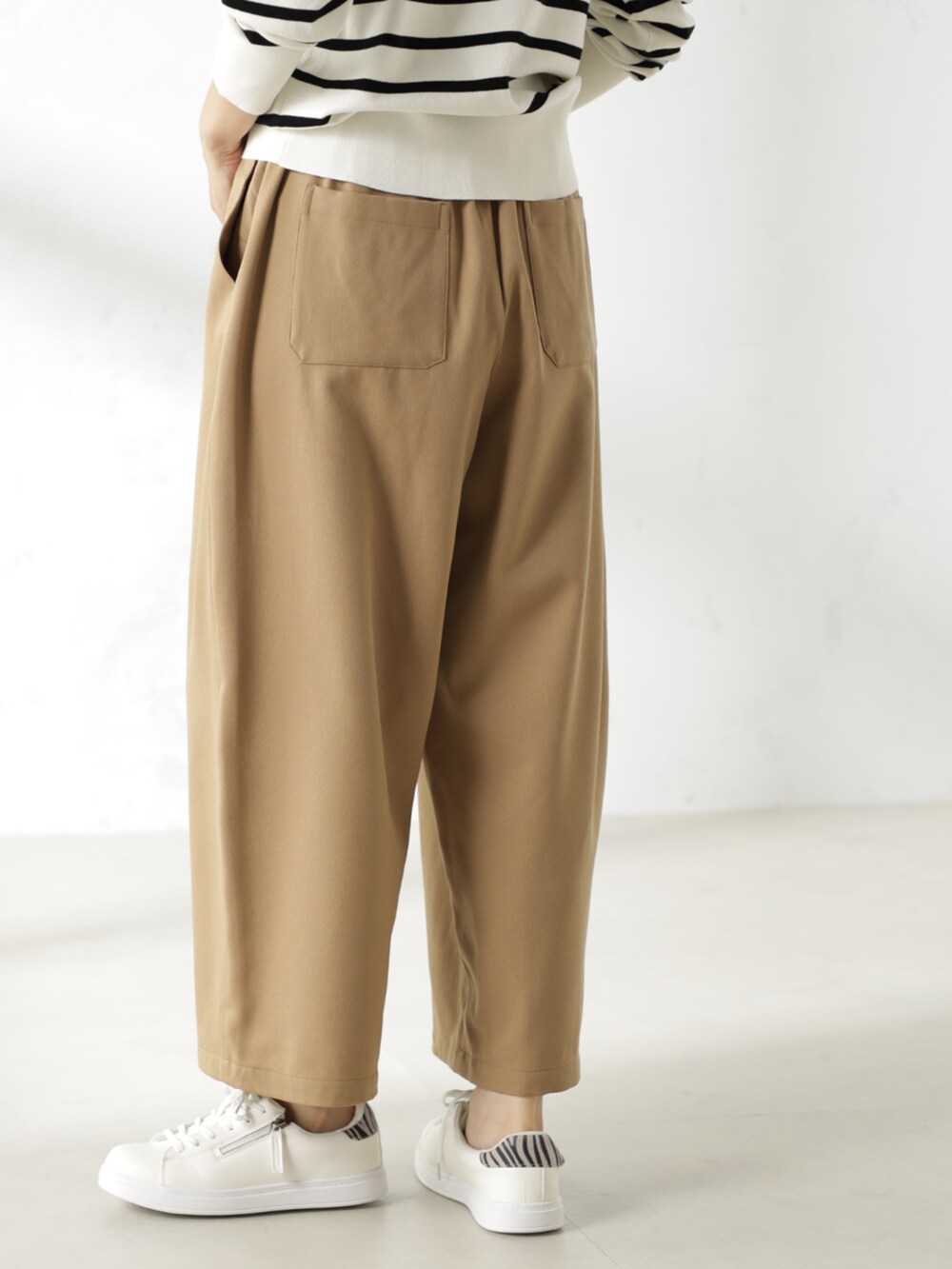 グレー系のニット/セーター、ベージュ系のその他パンツを着用したレディースの冬コーディネートの3枚目の写真