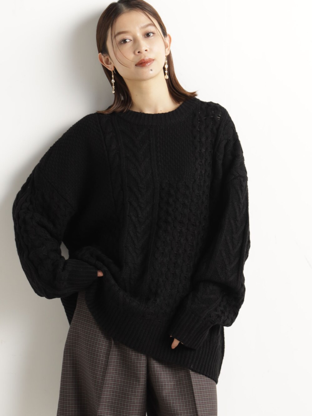 ブラウン系のその他パンツ、ブラック系のニット/セーター、ブラック系のハンドバッグを着用したレディースの冬コーディネートの2枚目の写真