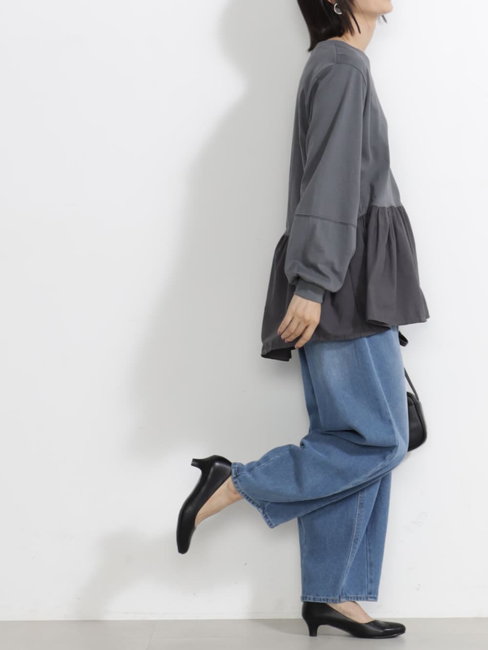 ブルー系のデニムパンツ、グレー系のTシャツ/カットソーを着用したレディースの秋コーディネートの2枚目の写真