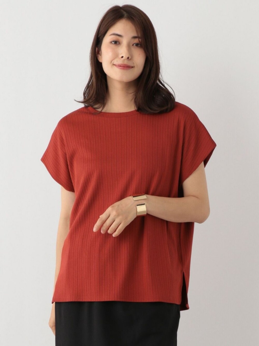 オレンジ系のTシャツ/カットソーを着用したレディースの春コーディネートの2枚目の写真
