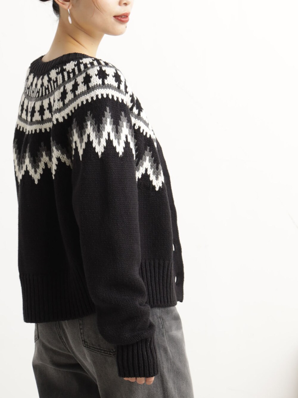 グレー系のデニムパンツ、ブラック系のニット/セーターを着用したレディースの冬コーディネートの3枚目の写真