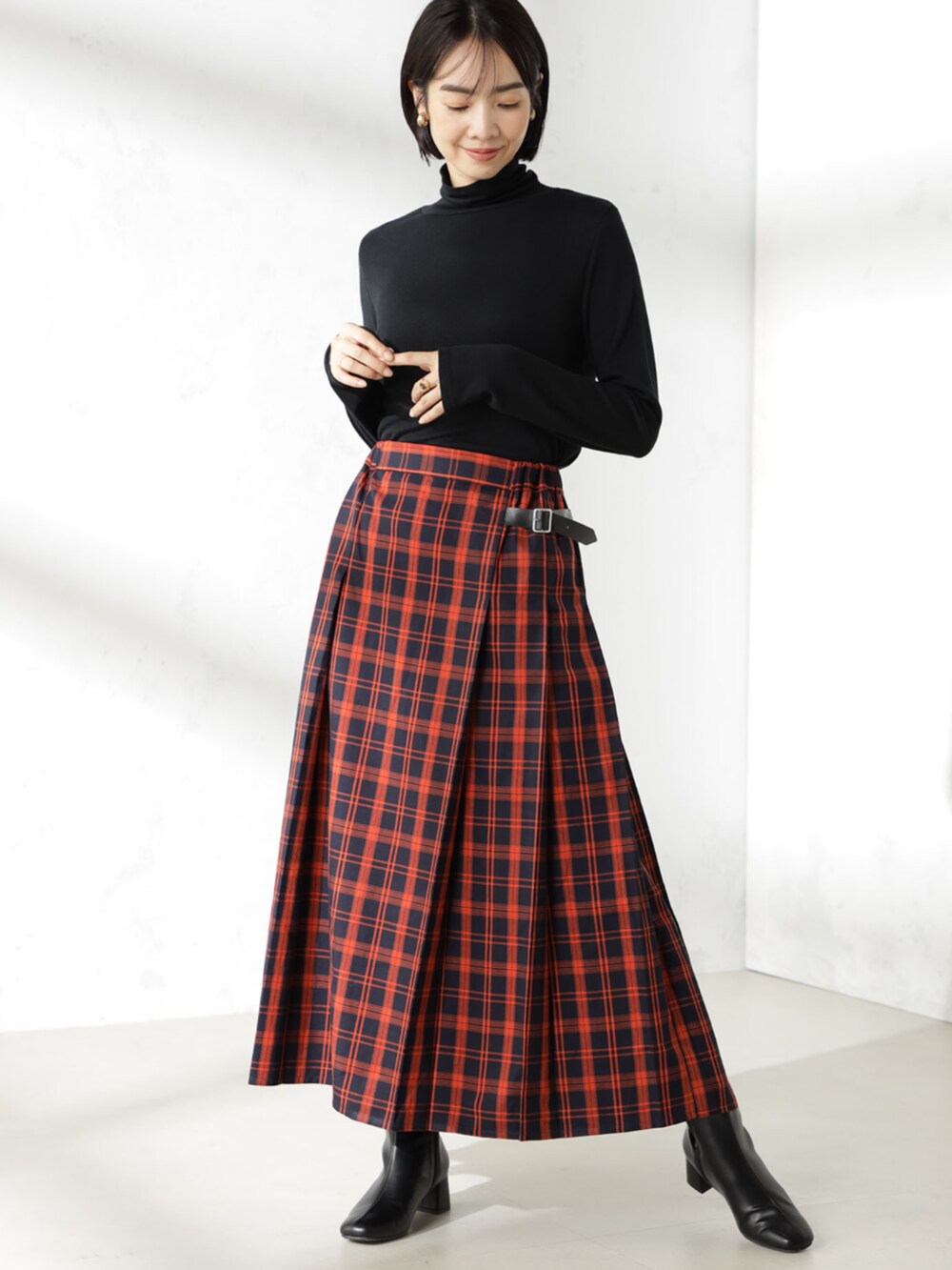 ブラック系のブーツ、ブルー系のスカート、ブラック系のニット/セーターを着用したレディースの秋コーディネートの3枚目の写真