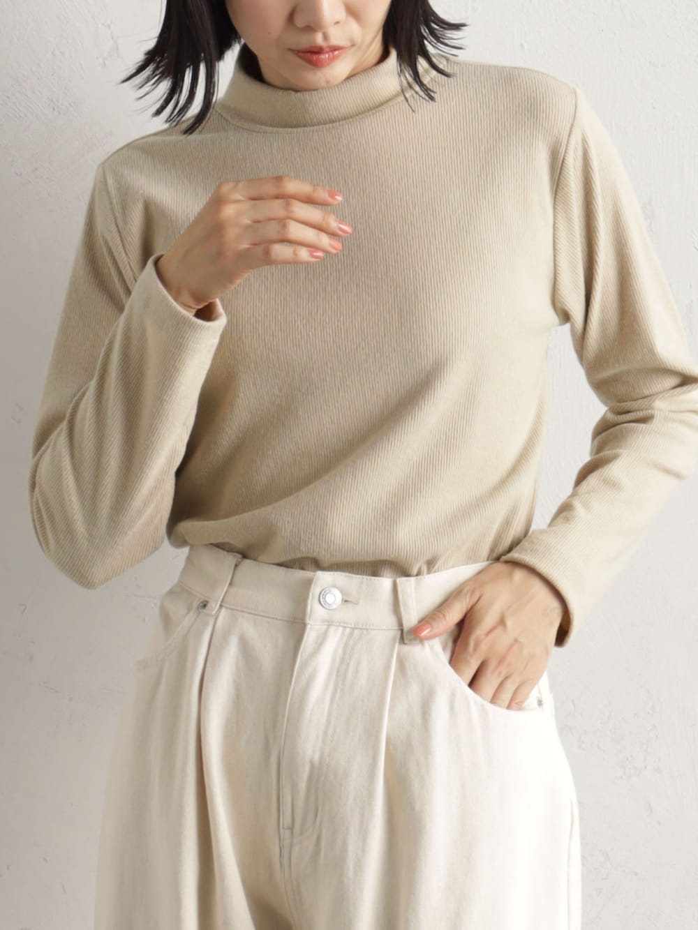 ホワイト系のデニムパンツ、ベージュ系のハンドバッグ、ベージュ系のTシャツ/カットソーを着用したレディースの冬コーディネートの2枚目の写真