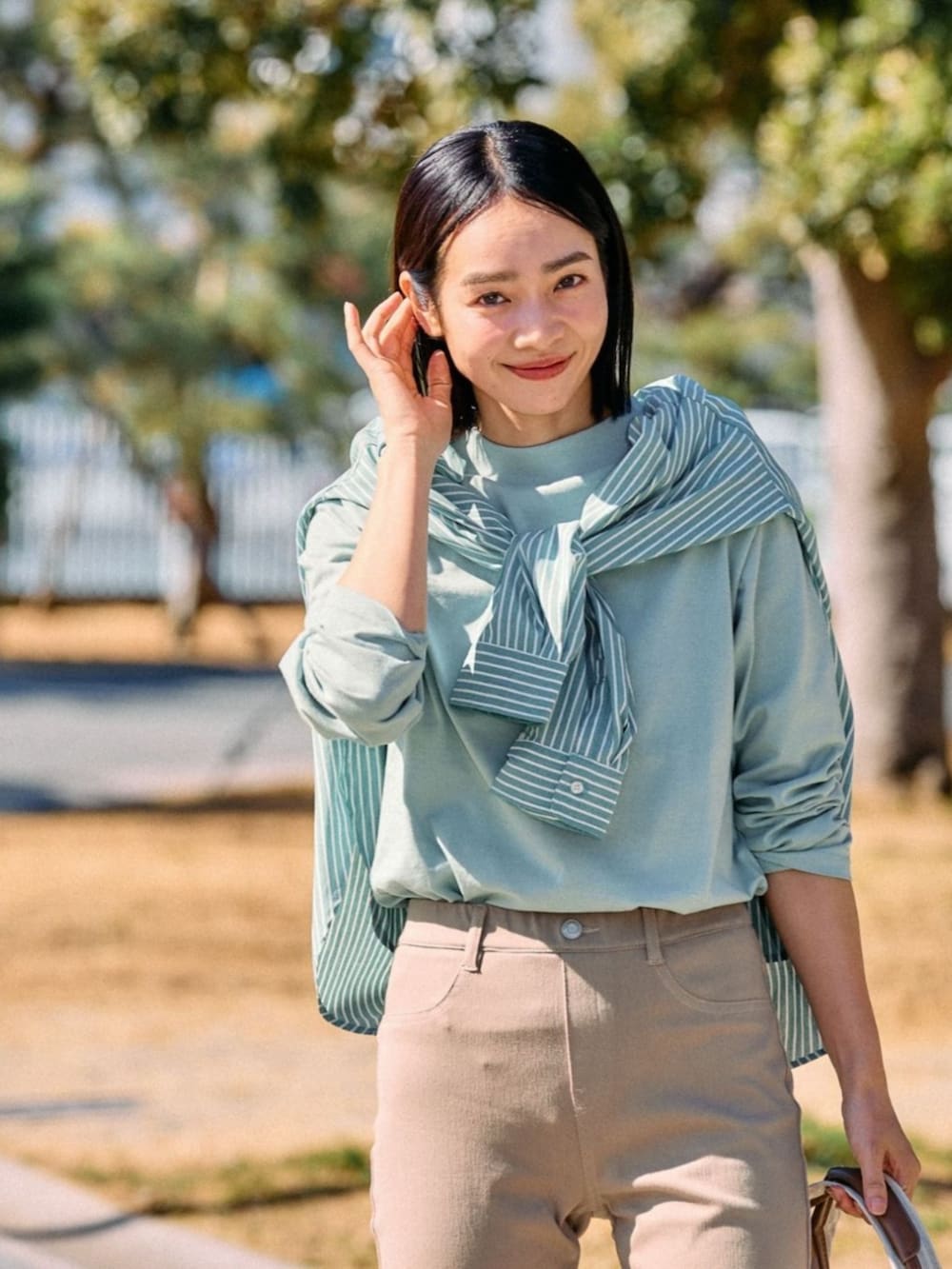 グリーン系のシャツ/ブラウスを着用したレディースの春コーディネートの2枚目の写真