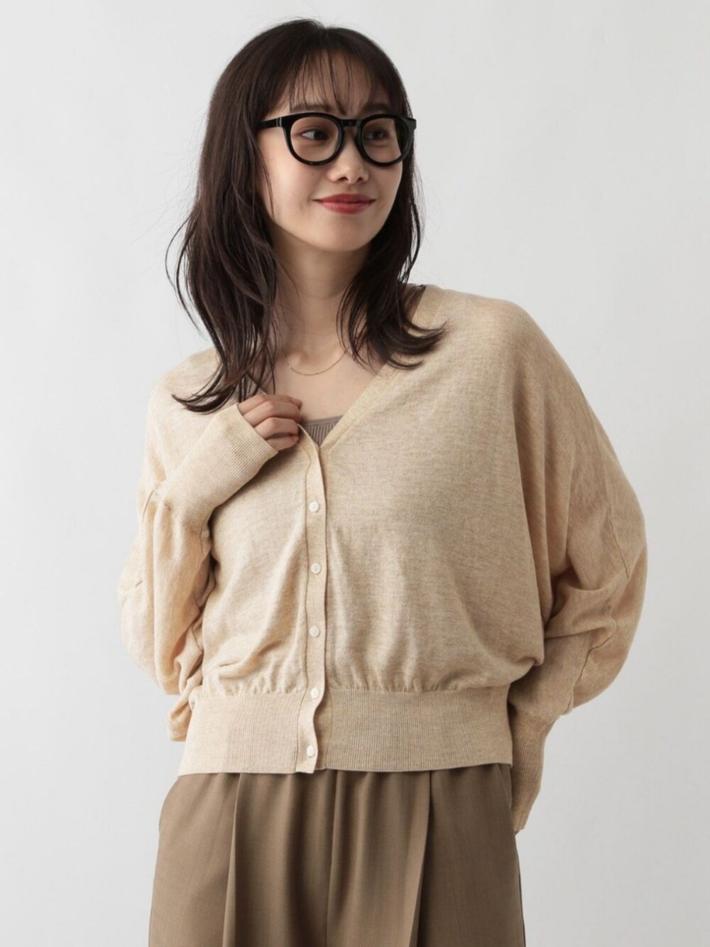 ベージュ系のカーディガン/ボレロを着用したレディースの冬コーディネートの2枚目の写真