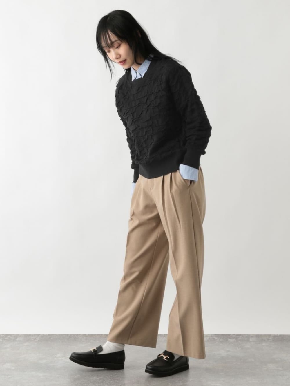 ブラック系のニット/セーターを着用したレディースの冬コーディネートの2枚目の写真