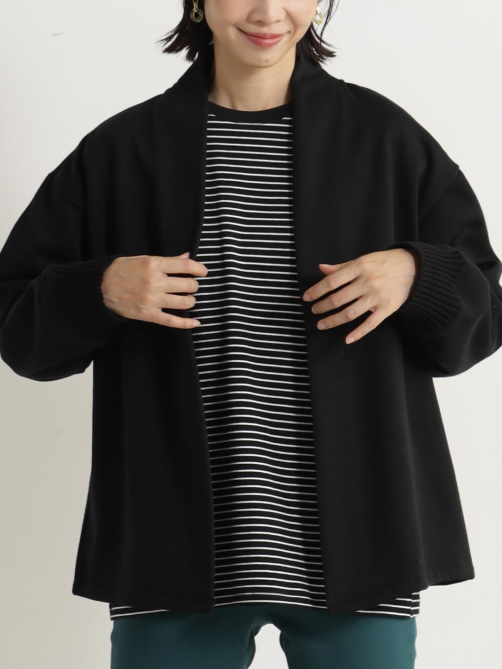 グリーン系のその他パンツ、ブラック系のカーディガン/ボレロ、ブラック系のパンプスを着用したレディースの冬コーディネートの2枚目の写真