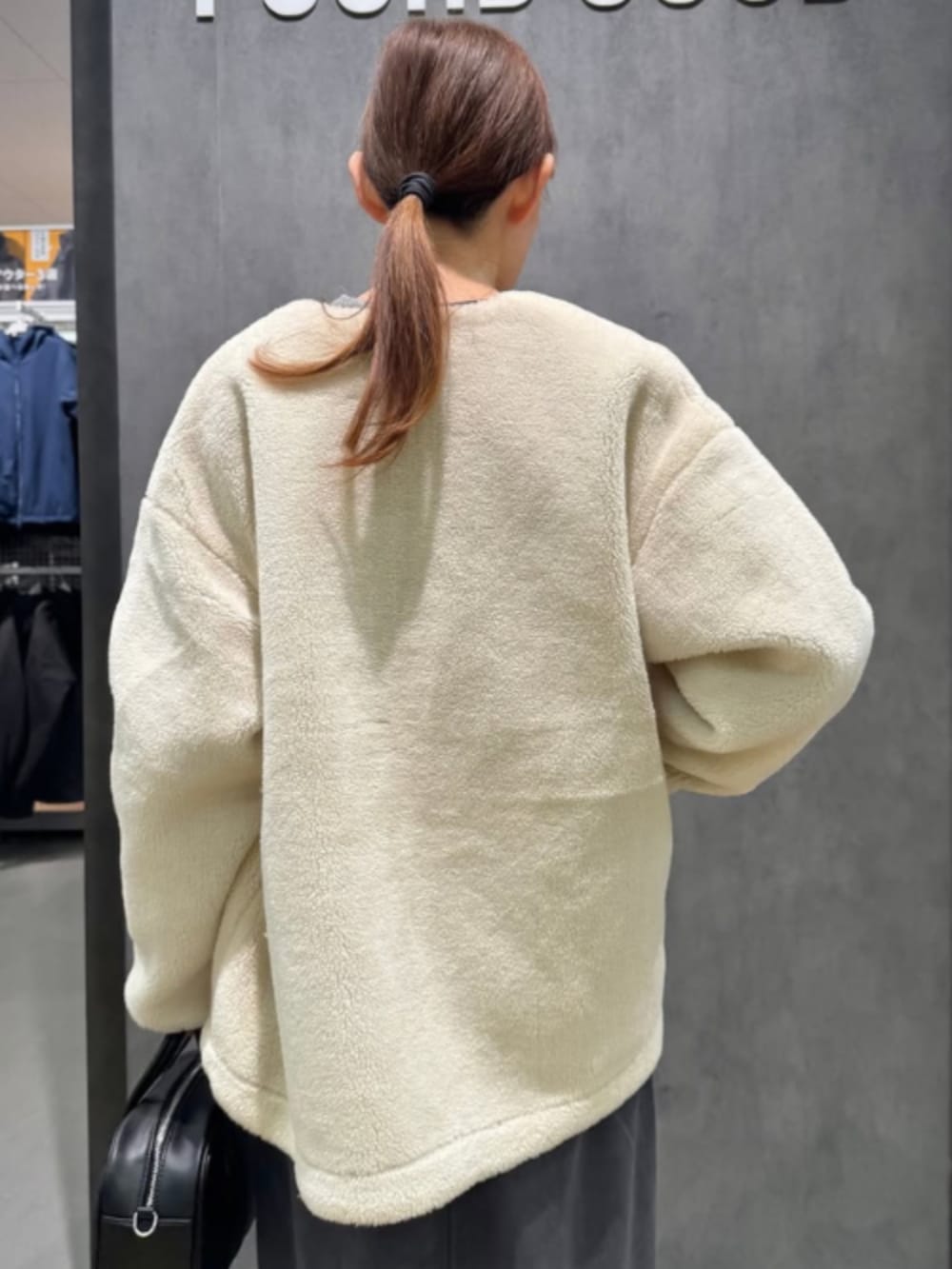 ブラック系のブルゾン、グレー系のニット/セーター、グレー系のスカートを着用したレディースの冬コーディネートの4枚目の写真