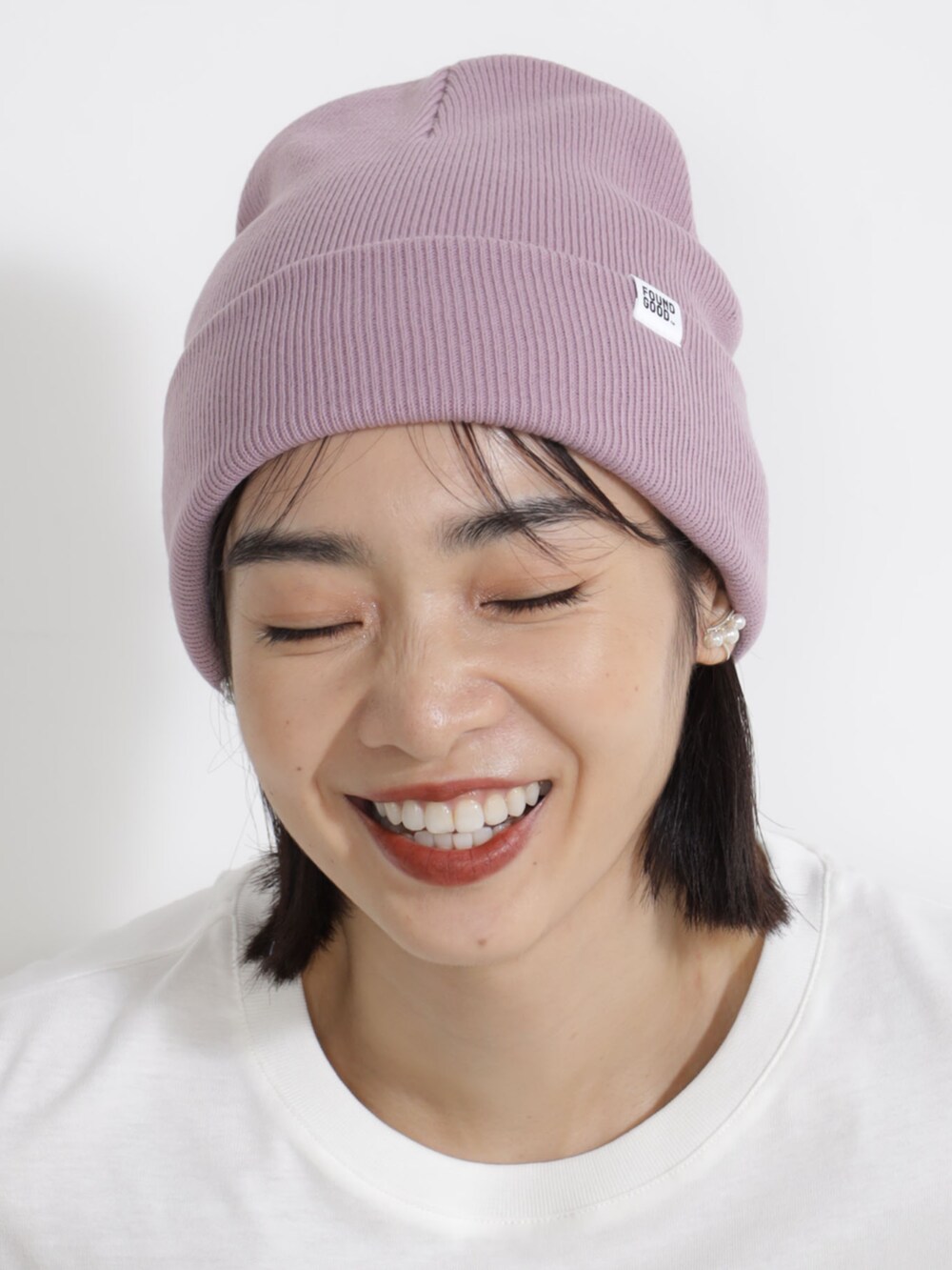 ベージュ系のTシャツ/カットソー、パープル系のキャップを着用したレディースの秋コーディネートの2枚目の写真