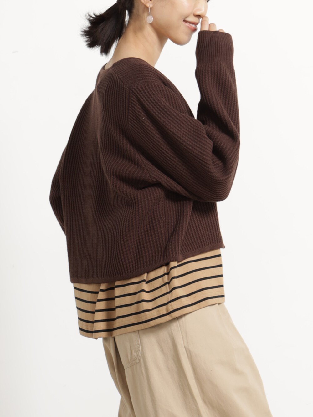 ベージュ系のチノパンツ、ベージュ系のTシャツ/カットソー、ブラウン系のカーディガン/ボレロを着用したレディースの秋コーディネートの2枚目の写真