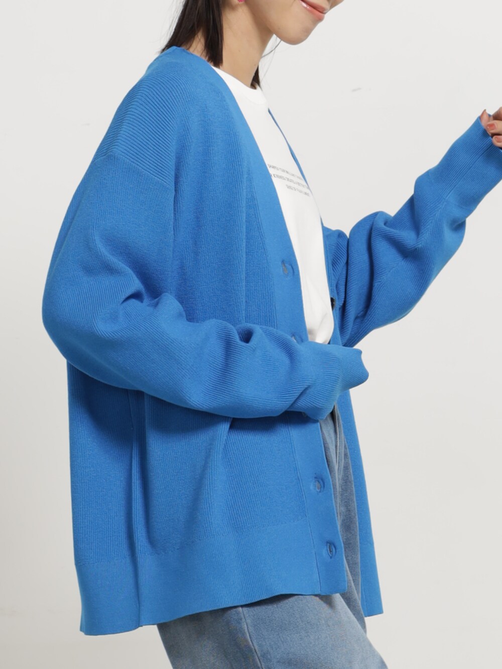 ブルー系のデニムパンツ、ブルー系のカーディガン/ボレロ、ホワイト系のTシャツ/カットソーを着用したレディースの秋コーディネートの2枚目の写真