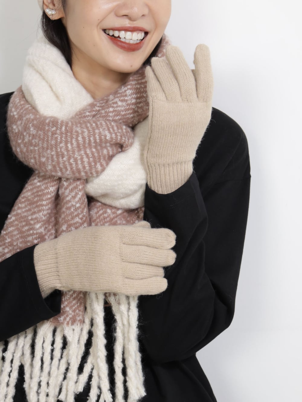 ベージュ系のマフラー、ベージュ系のキャップ、ベージュ系の手袋を着用したレディースの秋コーディネートの2枚目の写真